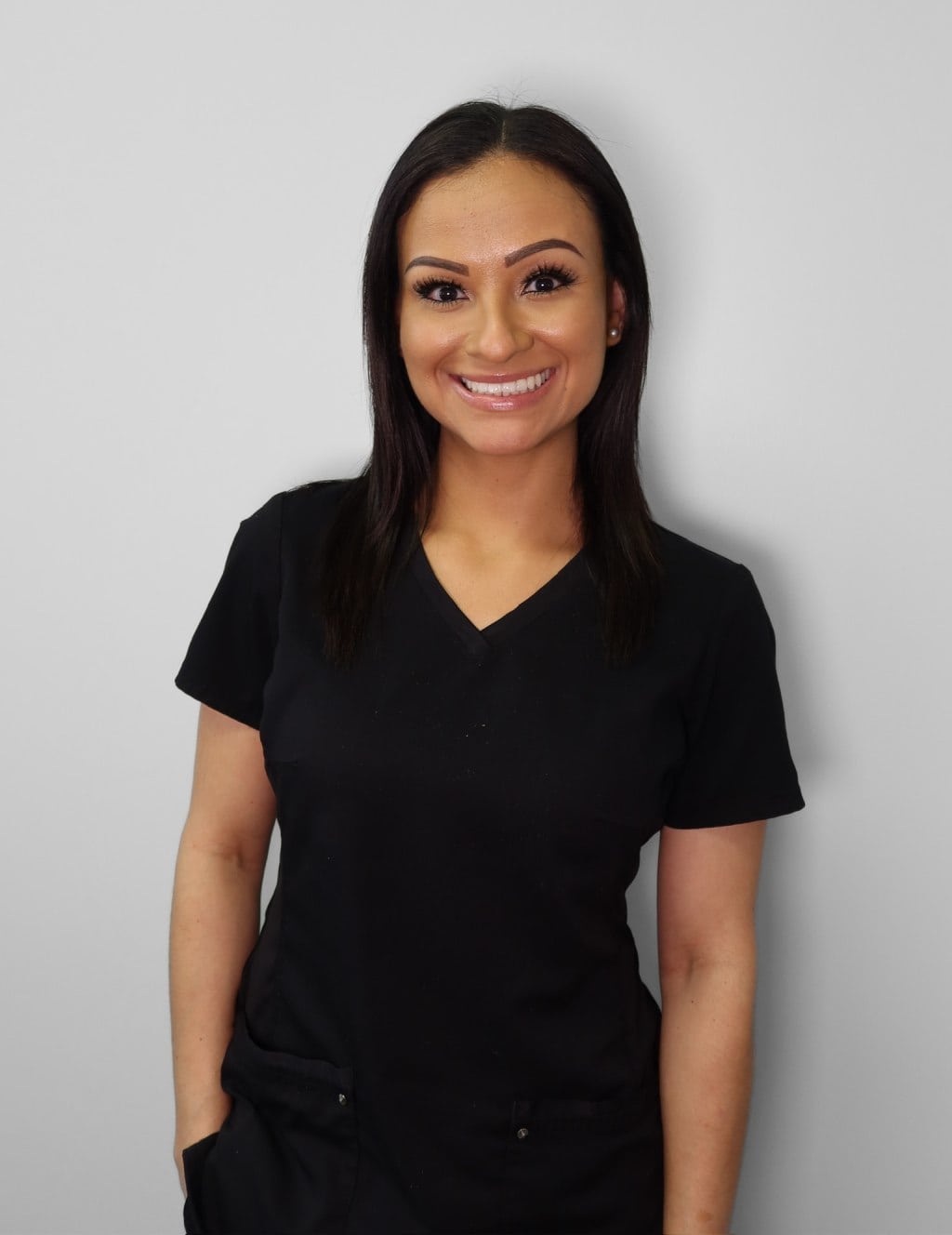 Thatiana, Braces Now orthodontic assistant smiling in black scrubs.