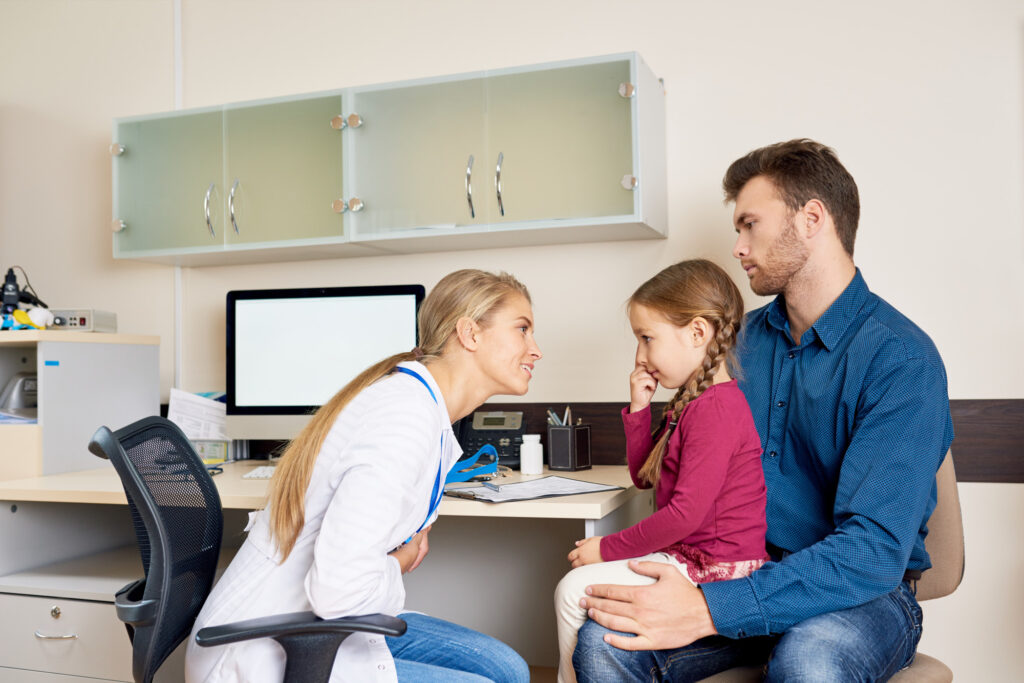 Parent and child at a dental office front desk discussing payment options